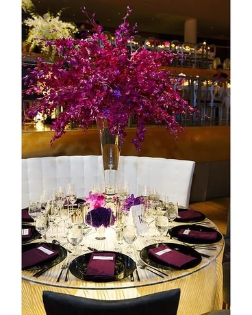 A tall glass centerpiece features Flower Arrangement